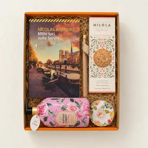 Una box Bookted già composta: il libro, i biscotti, la candela e il sapone nella scatola arancione